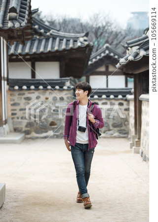 A young man holding a camera and taking pictures during a trip to Korea 105669114