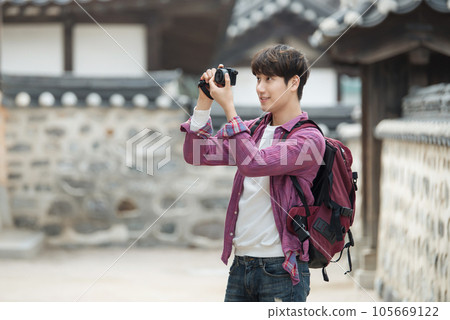 A young man holding a camera and taking pictures during a trip to Korea A young man holding a camera and taking pictures during a trip to Korea 105669122
