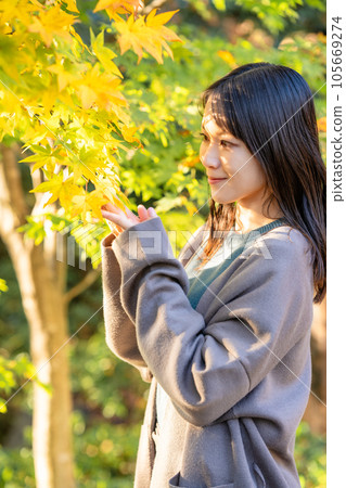 Young woman enjoying autumn leaves hunting 105669274