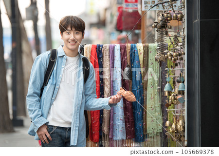 a young man walking on the streets of Korea 105669378