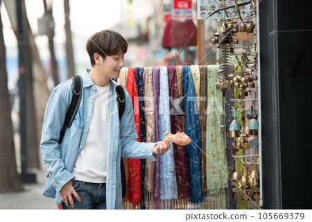a young man walking on the streets of Korea 105669379