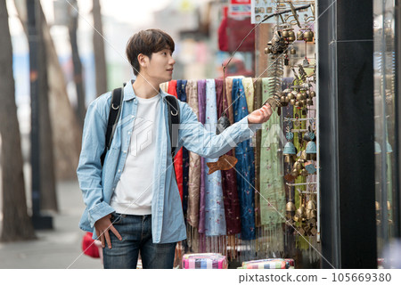 a young man walking on the streets of Korea 105669380