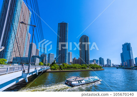 Tokyo cityscape in Japan View of the water bus "Emeraldas" passing through the Chuo Bridge and Okawabata River City 21 Tokyo cityscape in Japan View of the water bus "Emeraldas" passing through the Chuo Bridge and Okawabata River City 21 105670140