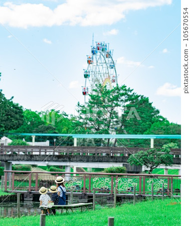 父母和孩子坐在遊樂園裡 105670554