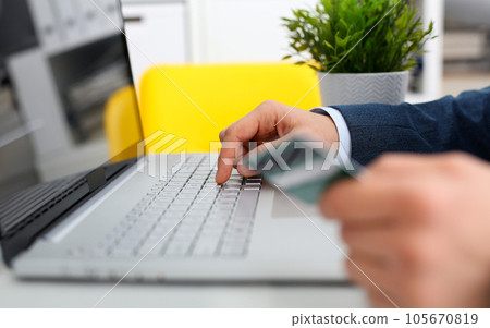 Male arms hold credit card press buttons Male arms hold credit card press buttons 105670819