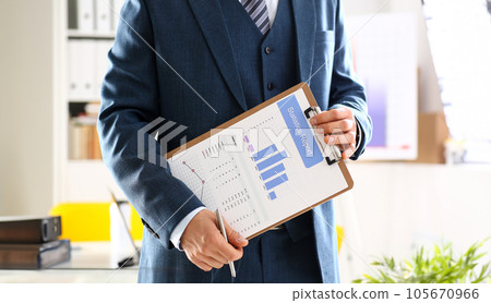 Male arm in suit show stats graphic clipped to pad 105670966