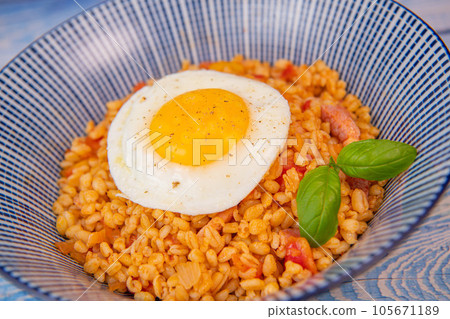 RECIPE FOR WHEAT WITH BACON, TOMATO AND SHALLOTS, SERVED WITH FRIED EGG RECIPE FOR WHEAT WITH BACON, TOMATO AND SHALLOTS, SERVED WITH FRIED EGG 105671189