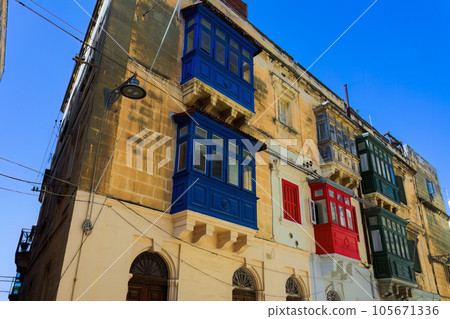 Traditional Maltese limestone buildings with coloured balconies in the vibrant alleys of the old city Birgu, Citta Vittoriosa without crowd. 105671336