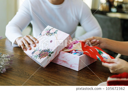 Surprise! romantic couple Hold present box with gift happy boyfriend and girlfriend. Valentine present. Gift box and red ribbon for romantic couple 105672362