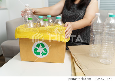 Home recycle eco green zero concept Woman throwing empty plastic bottle in recycling bin with yellow garbage bags at home. Home recycle eco green zero concept Woman throwing empty plastic bottle in recycling bin with yellow garbage bags at home. 105672468