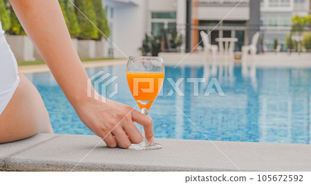Summer holiday Young asian Beautiful woman relaxing in swimming pool at spa resort. Beautiful tropical beach front hotel resort with swimming pool 105672592