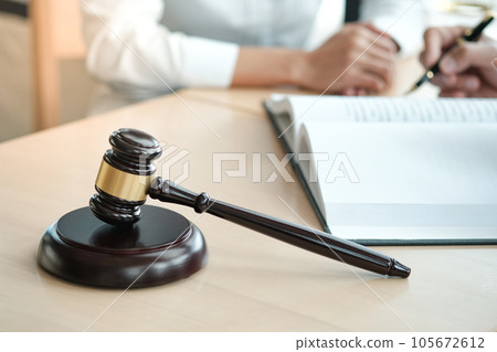 Legal counsel presents to the client a signed contract with gavel and legal law. justice and lawyer concept. 105672612