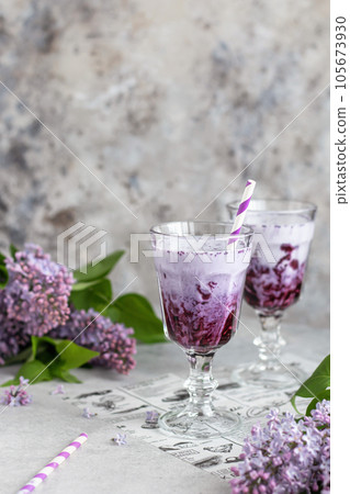 Milkshake with blueberries on gray background with lilac flowers. Vegatarian, healthy eating 105673930