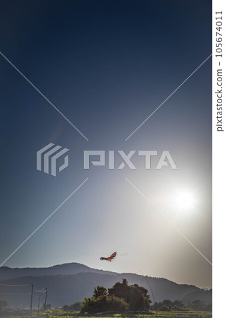 In the early autumn of Kyoto, in the sky of the Sagano countryside where the smoke from burning fields floats, a kite that protects the autumn harvest flies to repel birds. 105674011