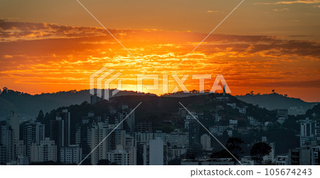 Early Dawn in the City with Silhouetted Buildings Against Orange Sky Early Dawn in the City with Silhouetted Buildings Against Orange Sky 105674243