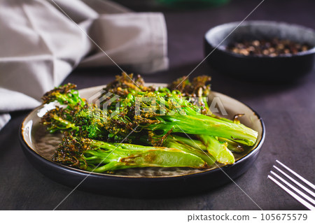 Fried green broccoli sprouts on a plate on the table Fried green broccoli sprouts on a plate on the table 105675579