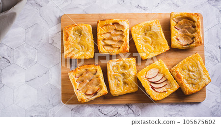 Small upside-down puff pastry cakes with banana and apple on a board top view web banner Small upside-down puff pastry cakes with banana and apple on a board top view web banner 105675602