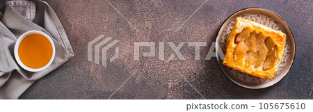 Small upside down puff pastry cake with apple on a plate top view web banner Small upside down puff pastry cake with apple on a plate top view web banner 105675610