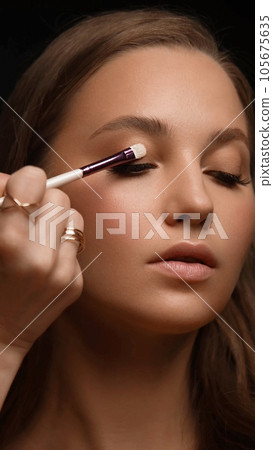 Beautiful young woman with a light natural make-up, brush for cosmetics and perfect skin. Beautiful young woman with a light natural make-up, brush for cosmetics and perfect skin. 105675635