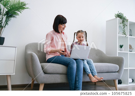 Ladies greeting relative during online video call via laptop 105675825