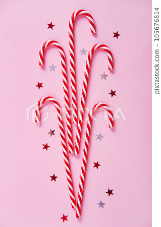Christmas composition. Candy canes, holiday decorations on a pink background. Christmas composition. Candy canes, holiday decorations on a pink background. 105676814