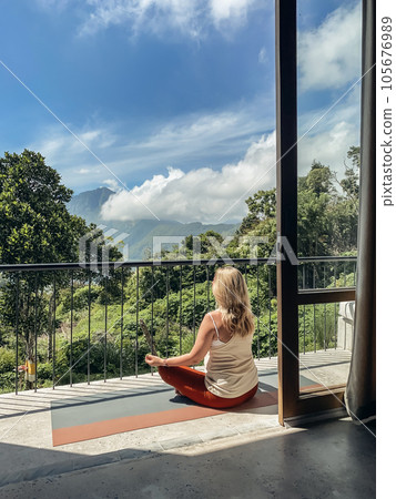 Middle-aged woman practicing yoga on a balcony 105676989