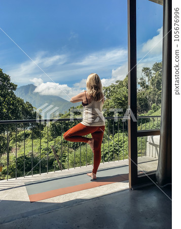 Middle-aged woman practicing yoga on a balcony 105676996
