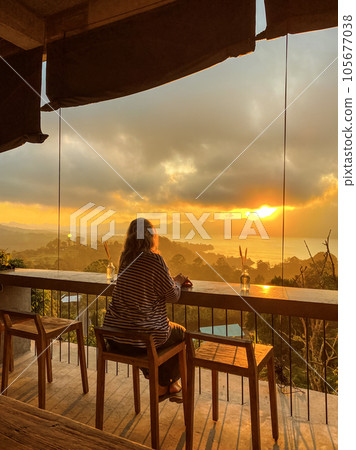 Woman watches amazing sunrise in the mountains 105677038