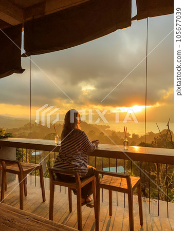 Woman watches amazing sunrise in the mountains Woman watches amazing sunrise in the mountains 105677039