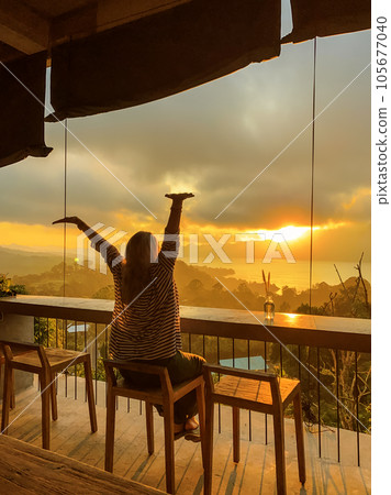 Woman watches amazing sunrise in the mountains Woman watches amazing sunrise in the mountains 105677040