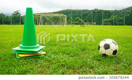 A water bottle and a cone on the soccer field 105679244