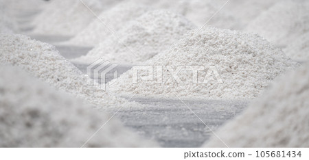 Sea salt farm. Pile of brine salt. Raw material of salt industrial. Sodium Chloride mineral. Evaporation and crystallization of sea water. White salt harvesting. Agriculture industry. Traditional farm 105681434