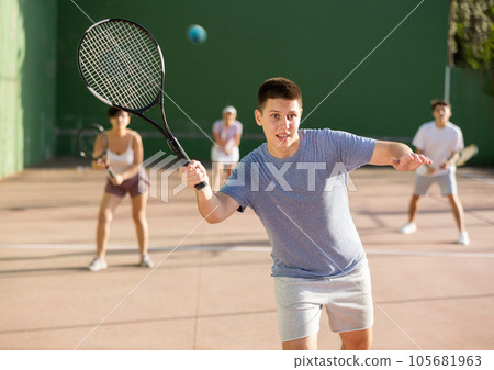 Young male pelota player hitting ball with racket 105681963