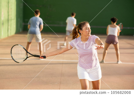 Woman playing frontenis with partners at sunny day, healthy lifestyle concept Woman playing frontenis with partners at sunny day, healthy lifestyle concept 105682008