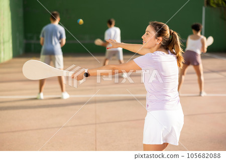 Sporty woman performing basic strokes during paleta fronton group training 105682088