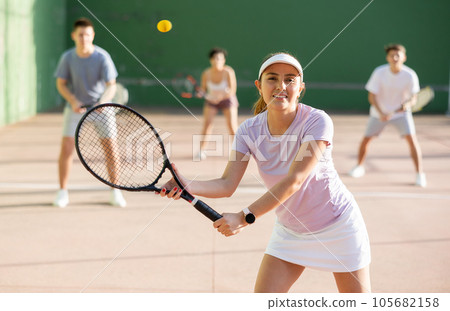Sportive woman in shorts and t-shirt playing frontenis on court 105682158