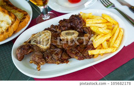 Baked veal on bone with fried potatoes Baked veal on bone with fried potatoes 105682178