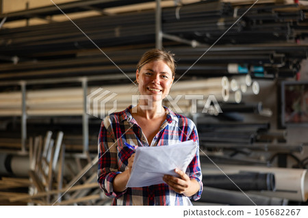 Cheerful woman checking documentation in warehouse 105682267