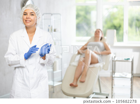 Doctor in disposable medical cap and gloves represents services provided in medical clinic Doctor in disposable medical cap and gloves represents services provided in medical clinic 105682278