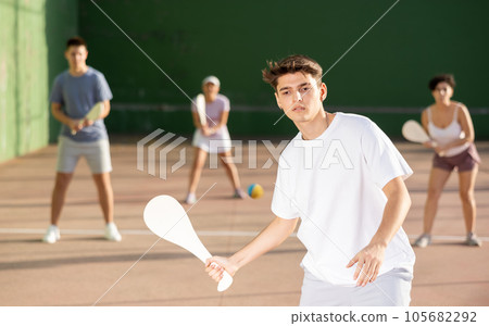 Young man serving ball during Basque pelota game outdoors 105682292