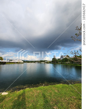 Singular rain dance: park and lake embrace under one cloud 105682417