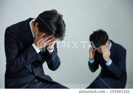 Businessman sitting down holding h 105683282