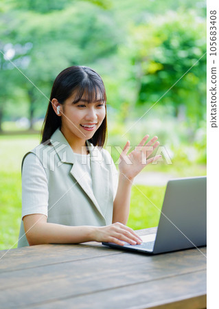 A woman using a laptop in the park 105683408