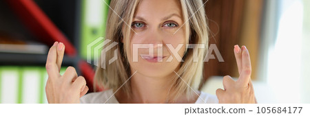 Blonde girl shows gesture with crossed fingers and looks at camera close-up. Blonde girl shows gesture with crossed fingers and looks at camera close-up. 105684177