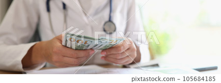 Doctor counts money in her hands in medical clinic. Doctor counts money in her hands in medical clinic. 105684185