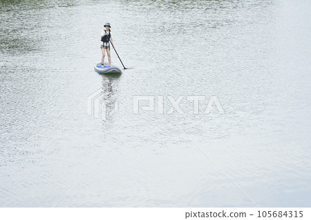 Japanese woman enjoying SUP on the river on holiday Japanese woman enjoying SUP on the river on holiday 105684315