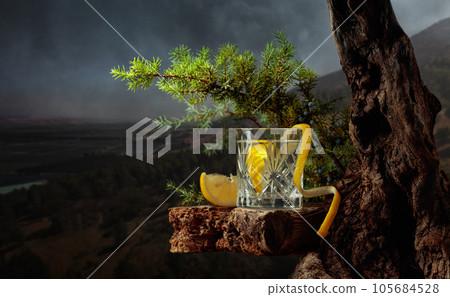 Cocktail gin-tonic with lemon in a crystal glass on an old board. Cocktail gin-tonic with lemon in a crystal glass on an old board. 105684528