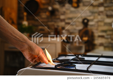 Unrecognizable man lights gas on the stove 105685978