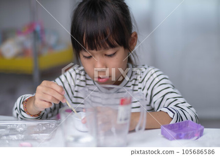 Cute little girl making DIY plaster and painting at home. Children paint on plaster sculptures with family on holiday. Imagination and creativity activities. 105686586