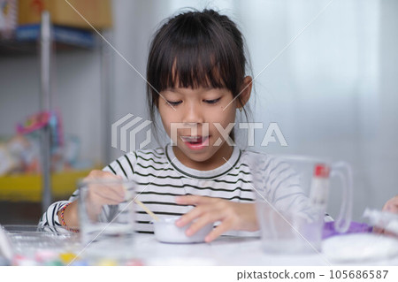 Cute little girl making DIY plaster and painting at home. Children paint on plaster sculptures with family on holiday. Imagination and creativity activities. 105686587